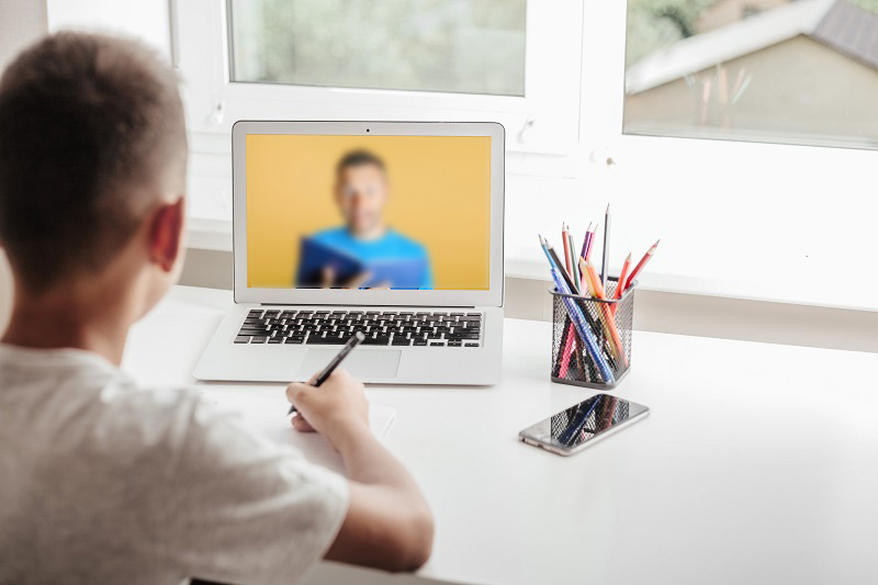 school at home through online homeschooling. the child is sitting at the computer