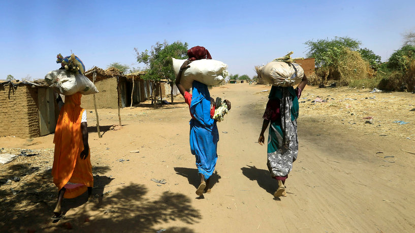 Internally displaced Sudanese women carry bags of farm products on their heads as they walk within the Kalma camp for internally displaced persons (IDPs) in Darfur, Sudan April 25, 2019. REUTERS/Mohamed Nureldin Abdallah